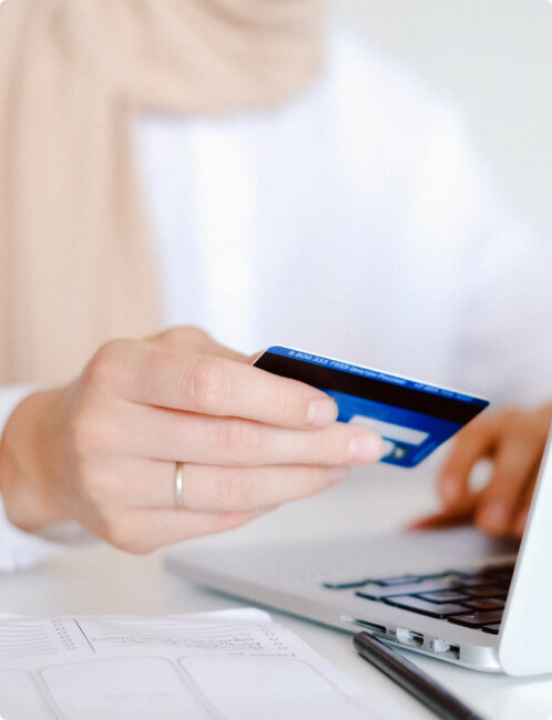 Person holding a credit card to make a payment in the computer